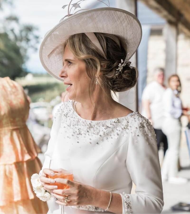 Model wearing a white dress and a hat