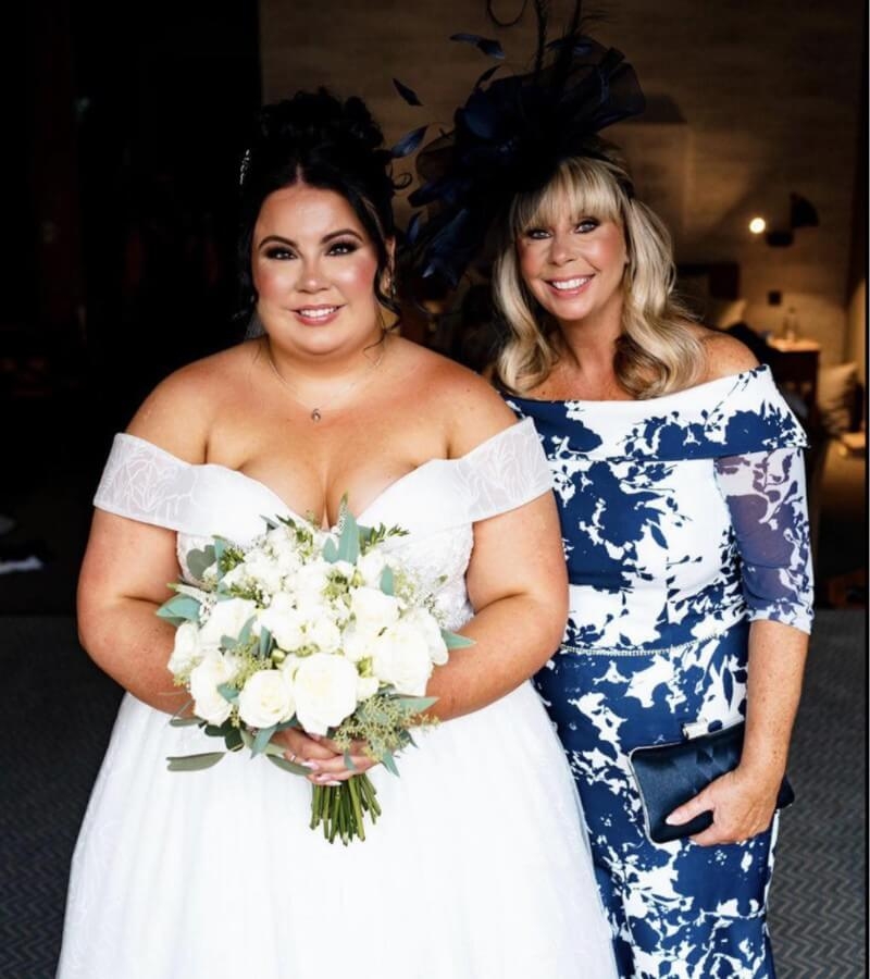 Model wearing a white gown with flowers